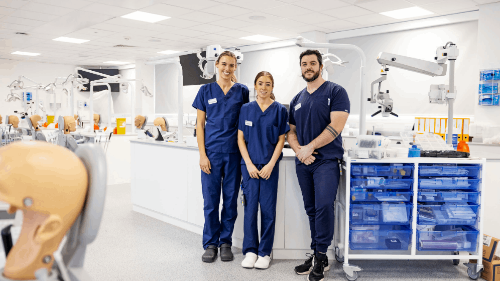 three students standing in a group on the teaching clinic